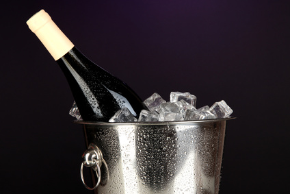 Bottle of wine in ice bucket on darck purple background