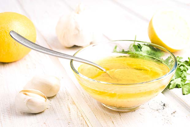 vinaigrette in a bowl and garlic and lemon to the side