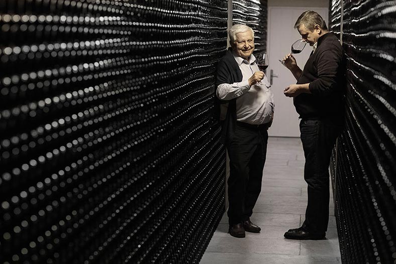 Members of the Amoreau family, owners of Chateau Le Puy, drinking a glass of its wine in the bottle cellar