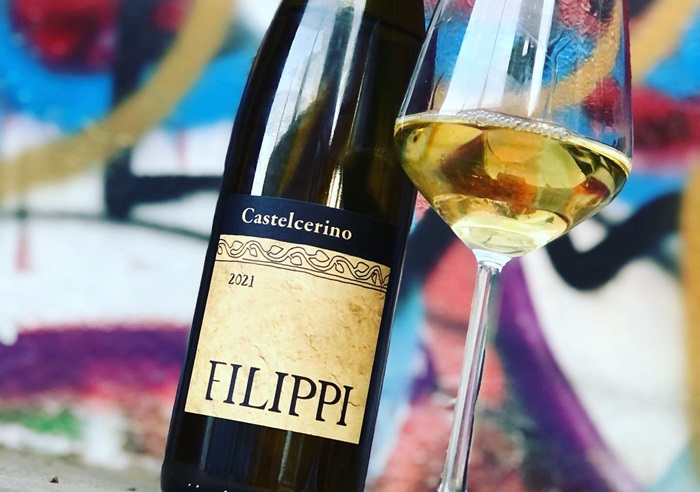 A bottle of Filippi's wine from 2021 with it poured into a wine glass along side it