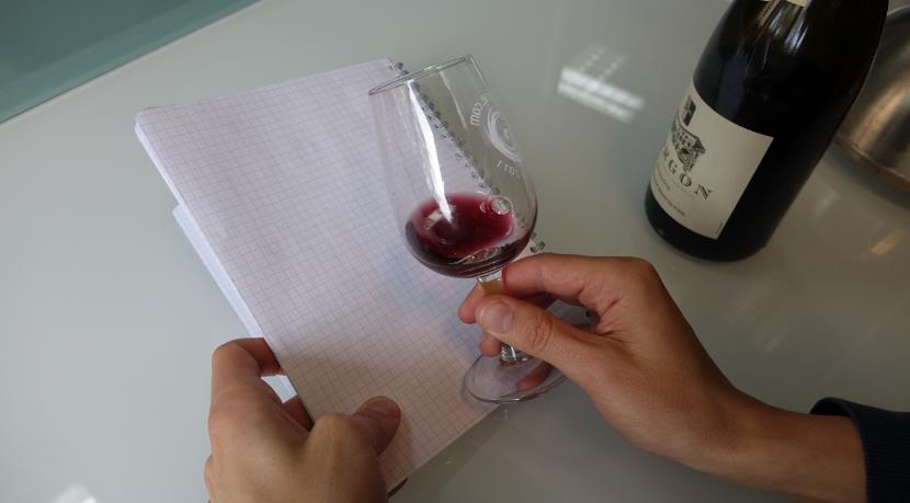 Hold red wine over a white surface to analyse the colour