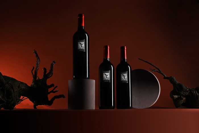three bottles of Screaming Eagle against a moody red
backdrop
