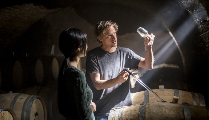 Félix Debavelaere in the cellar tasting wine from the barrel