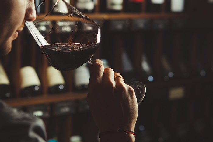 A person smelling a wine in a wine glass