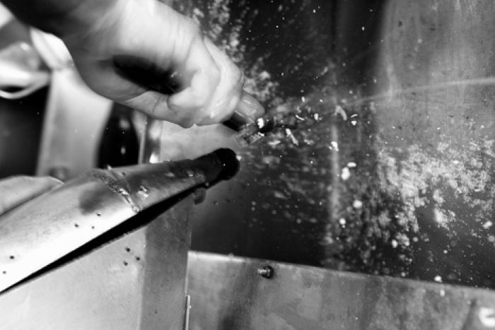 A Champagne bottle being disgorged