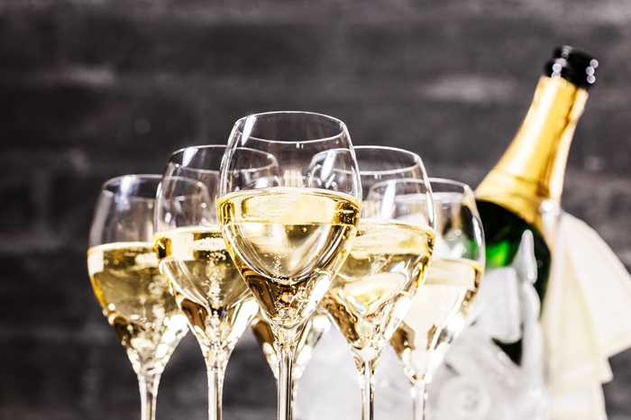 filled Champagne glasses with a Champagne bottle in the background